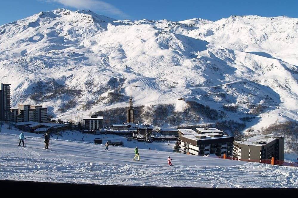Abfahrt auf Skiern auf einer grünen Piste. Volle Sonne auf der Terrasse 1