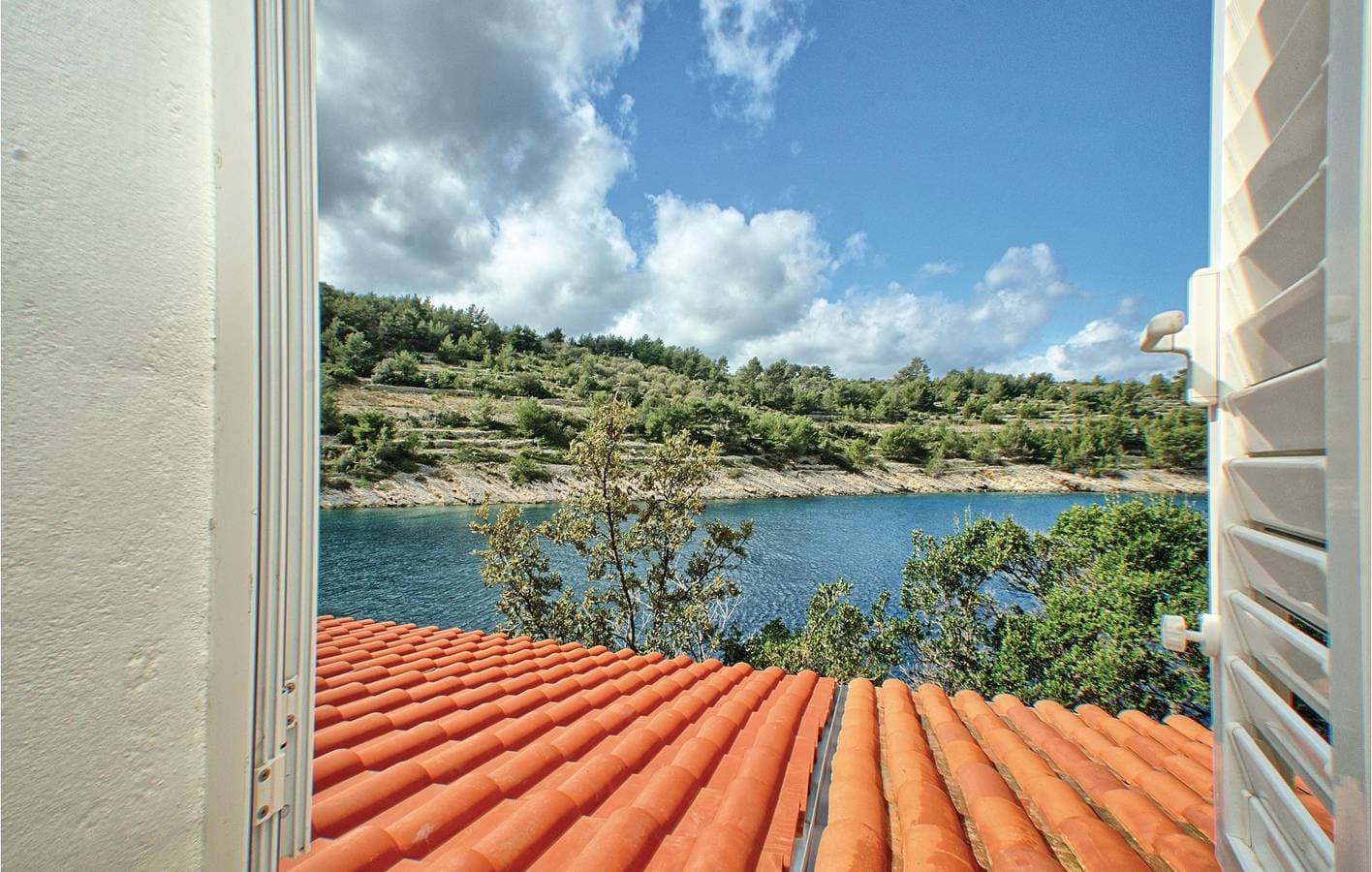 Foto 12 von 28: Gemütlich, 2 km vom Strand entfernt: Terrasse mit Blick aufs Wasser und Küche