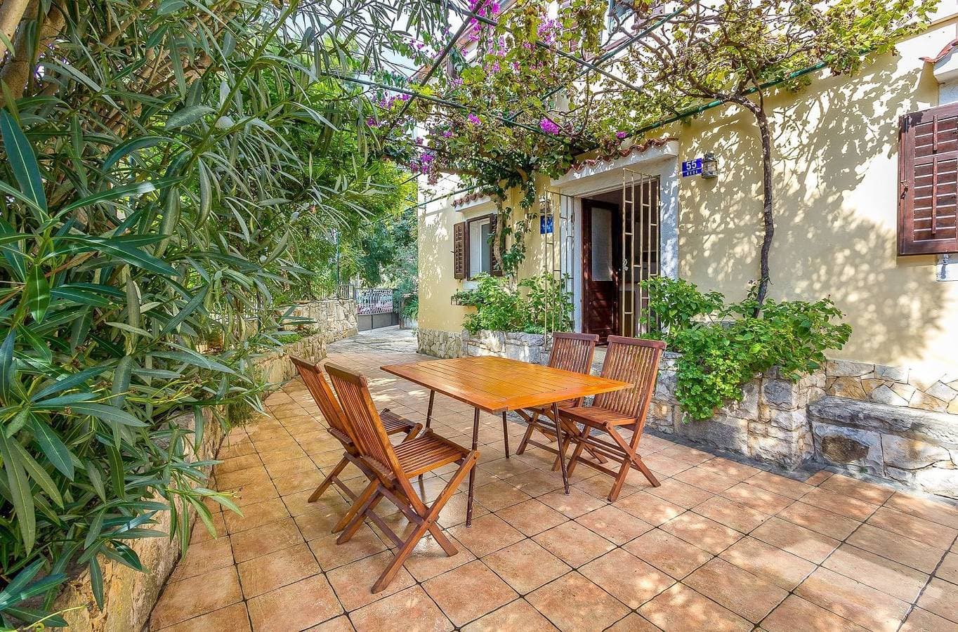 Komfortables Ferienhaus mit Palmen, Weinreben und Liegestühlen im Garten 1