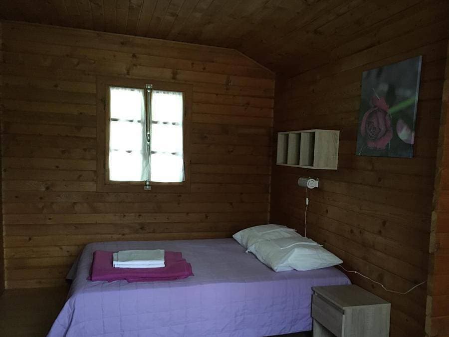 Foto 11 von 45: Les Chalets De Fiolles - Chalet 4 personen - Chalet Pmr Confort - 1 Schlafzimmer - Klimaanlage - TV - BBQ - Reinigung* - 35m2 + überdachte Terrasse von 14m2