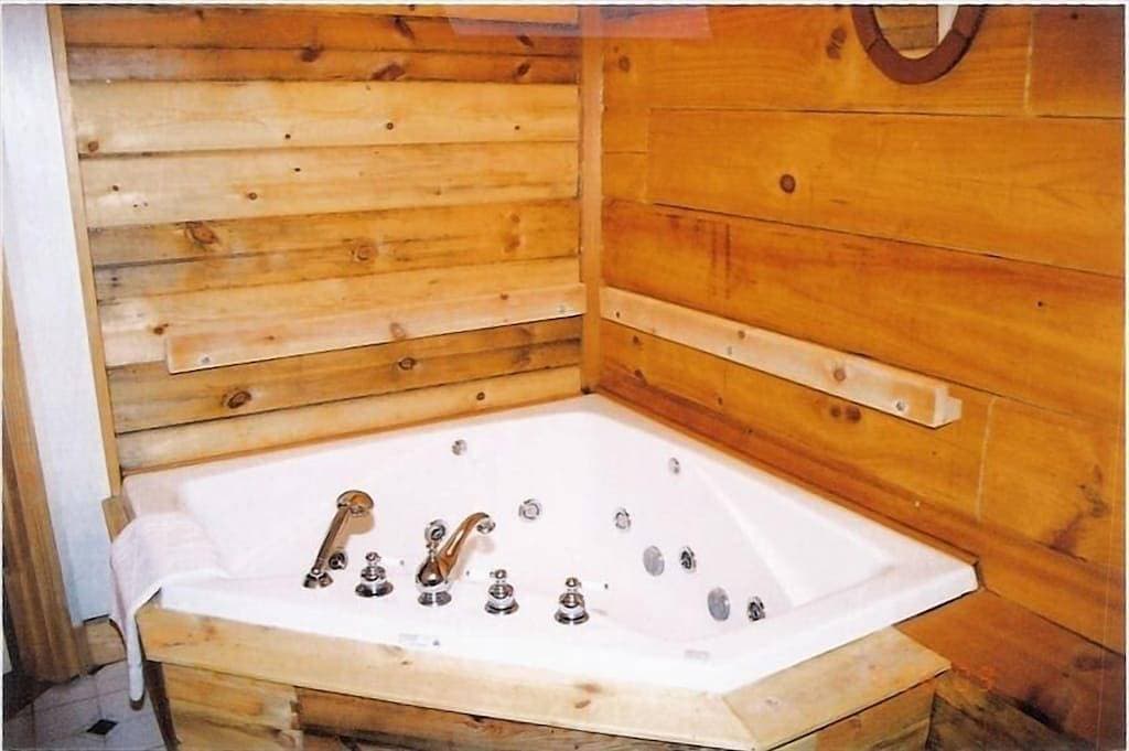 Foto 9 von 30: Abgeschiedenes Blockhaus. Heiße Wanne auf Deck und Whirlpool für zwei Personen am Kamin